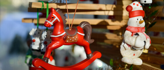 Décoration de Noël d'un cheval en bois rouge et d'un bonhomme de neige, accrochés à une branche...