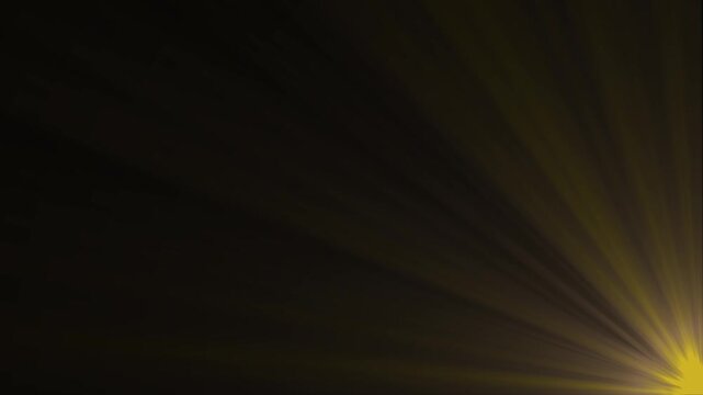 Golden sunburst rays emanating from bottom right corner dark background abstract light flare effect
