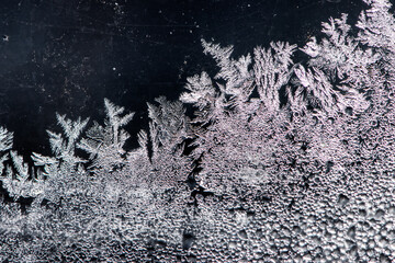 the image of frost on the glass. Subzero temperatures outside. Crystals of frozen water on glass. Beautiful pattern of frost on the window glass. ice, for text or image as background. macro photo