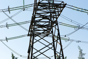 High voltage power line on blue sky background in Sunny day. wires, problems with electricity, power transmission. power line construction of cable supports and insulators. blackout, crisis