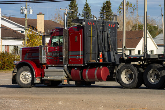 Canada, 14 October 2025 : Red semi truck parked near houses in small residential neighborhood area