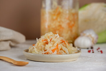 Homemade sauerkraut salad with carrots, pepper and garlic on a table. Healthy, probiotic food.