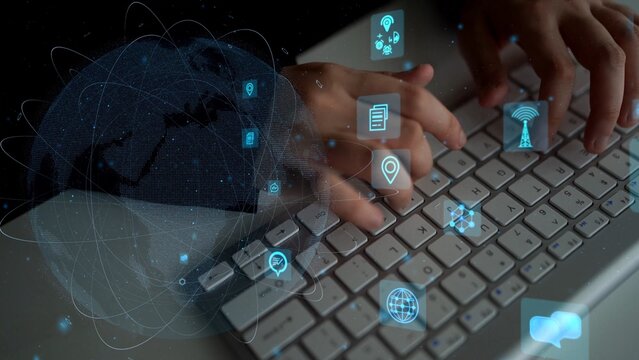 Close-up of hands typing on a keyboard in a modern workspace, overlaid with digital icons and a world map, representing global communication and technology. Xenic - Powered by Adobe