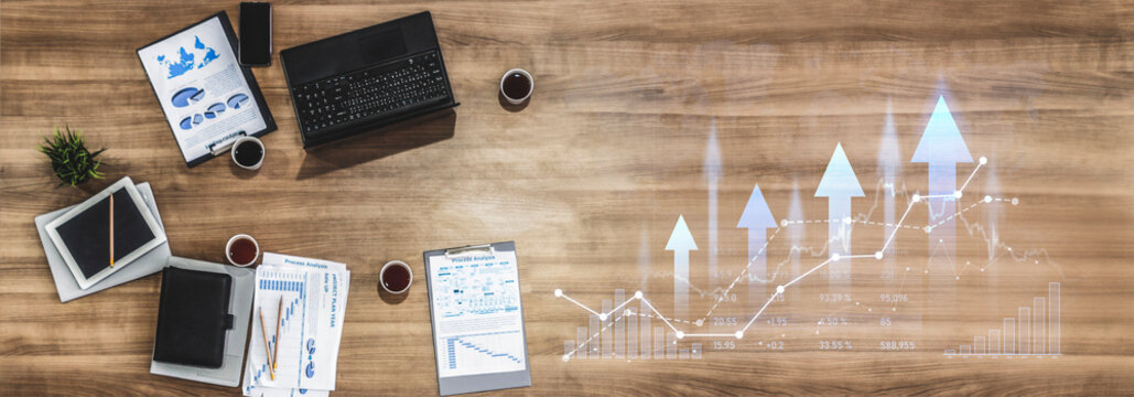 A modern workspace setup featuring various graphs, data analysis tools, and a laptop, highlighting a professional environment perfect for financial planning and decision-making. Scalp - Powered by Adobe