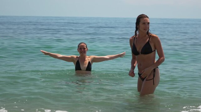 Women ocean swimming, two young women enjoying the clear blue sea.