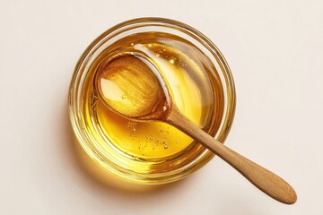 Golden liquid in a glass bowl with a wooden spoon