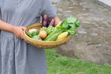 woman holding basket of vegetables