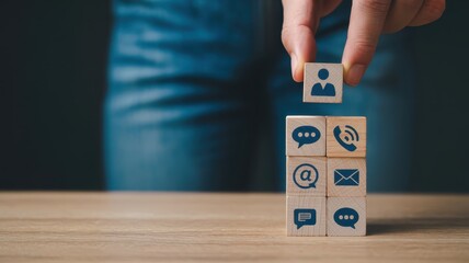 Human resource selection is accomplished by placing a communication icon block atop a stack of service options on a wooden surface.
