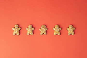 Gingerbread cookies in a row on red background. Sweet food, Christmas concept