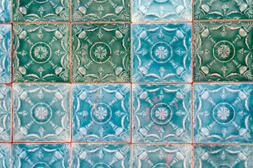 Close‑up of traditional Portuguese azulejos ceramic tiles in teal and turquoise, embossed floral pattern forming a repeating grid background for architecture, design, and cultural heritage concepts