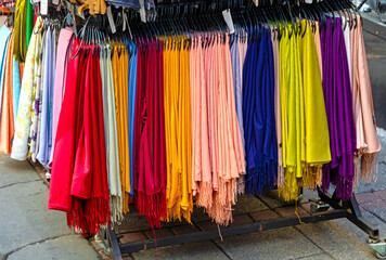 Soft colorful scarves hanging outside on market stall