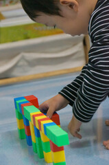 A child's hands building a structure using colorful blocks. This scene highlights creativity, learning, and play with colorful blocks.
