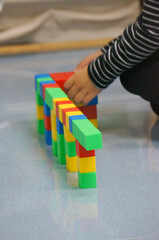 A child's hands building a structure using colorful blocks. This scene highlights creativity, learning, and play with colorful blocks.