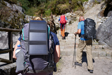 Hiker with solar panel on his backpack goes trekking in mountains of Nepal.