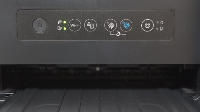A black plastic inkjet printer performs a nozzle check maintenance routine. The process creates a rhythmic series of mechanical sounds, including the whirring of the print head moving side-to-side