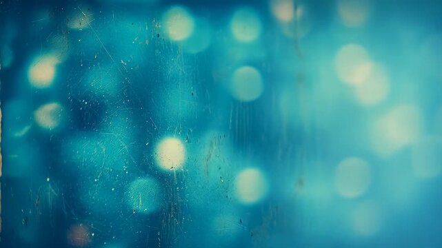 Abstract blue bokeh background viewed through a weathered glass pane with soft circular light orbs and vintage texture, evoking a moody, dreamy, nostalgic atmosphere for design