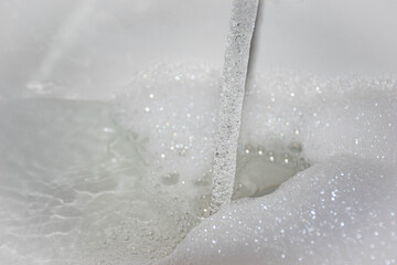 Running a bath with white fluffy foam 