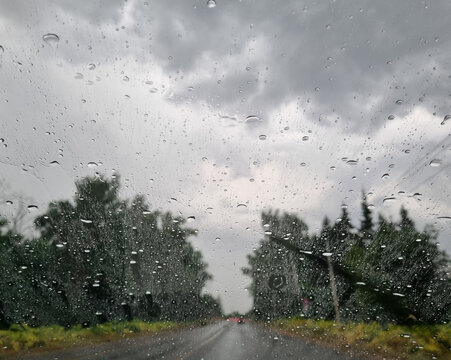 Rainy day on the road. Rain drops on the windshield.