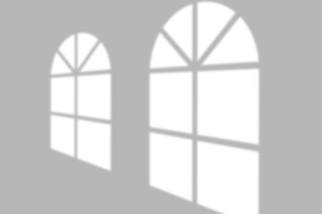 Soft window light shadows cast geometric patterns on a minimalist gray wall