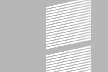 Soft morning light stripes cast by window blinds create a calm, modern atmosphere on a clean gray wall