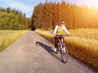 Fototapeta premium Female biker exploring nature on quiet country lane