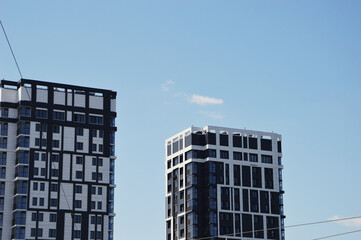 Obraz premium Two modern stylish high-rise residential apartment buildings with gray and white decorative elements of the facade. Urban architecture.