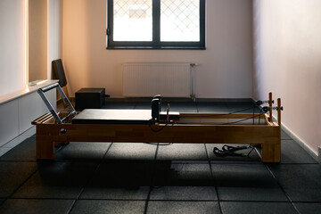 Pilates reformer machine in fitness studio.