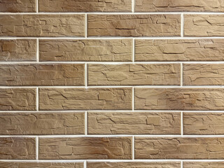 Brick wall with a brown and white color. The wall is made of bricks and has a rough texture.