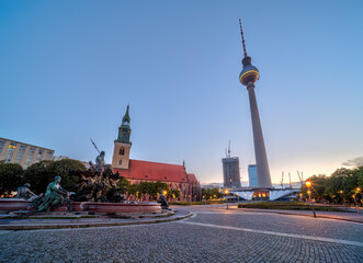 Obraz premium The Alexanderplatz in Berlin with the famous TV Tower and St. Marys church at dawn