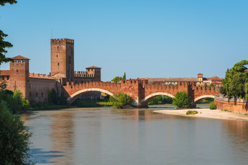 Ponte Scaligero, also known as the Castelvecchio Bridge, spanning the Adige River in Verona, Italy. A view during a sunny summer with a clear blue sky.