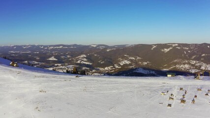 Old ski station on a snowy mountain slope with a lot of people on skis and snowboards