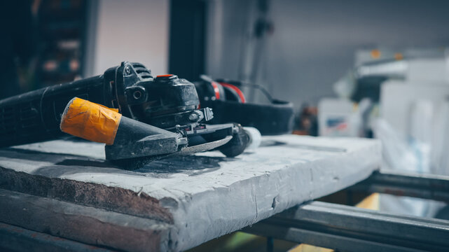 Angle grinder and safety equipment on a workbench in a workshop