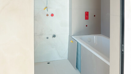 Bathroom renovation in progress with a new bathtub and tiled walls