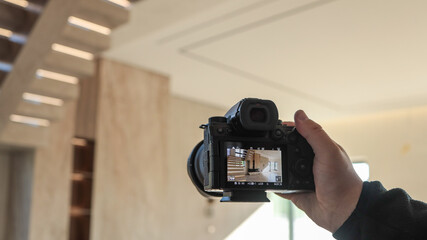 Photographer capturing a modern interior with a staircase and natural light