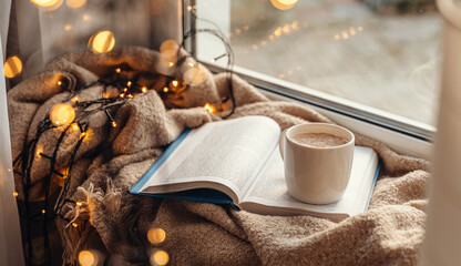 Cozy Christmas morning with warm blanket, cup of cocoa, and book