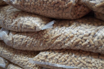 Bags of wood pellets (biofuel pellets) are stacked in transparent packaging.