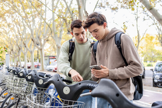 Brothers using smartphone app to unlock shared bike at city station