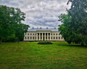 Obraz premium Cirkliskis Manor, located in Lithuania, features a neoclassical architectural style with a prominent portico supported by four large columns. The two-story building has a symmetrical facade