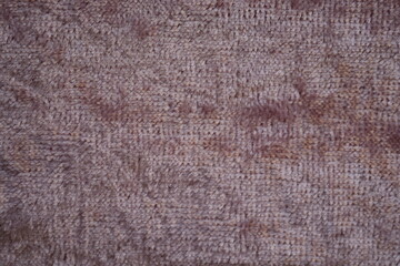 Fototapeta premium Dusty rose velour fabric texture, close-up macro view of dusty rose velour fabric showing its soft, plush surface and fine fibers. The detailed texture highlights the smooth, slightly fuzzy appearanc