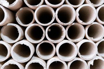 Close up view of stack of cylindrical cardboard tubes.