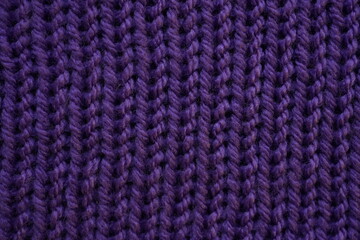 purple texture of knitted wool fabric as a background, purple smooth symmetrical lines of hand-knitted needlework pattern	
