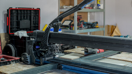 Tile cutter in use, cutting a ceramic tile for a construction project