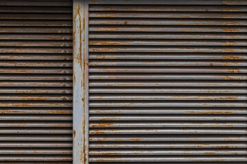 Background of old rusty and dust metal shutter doors in the abandoned gas station.