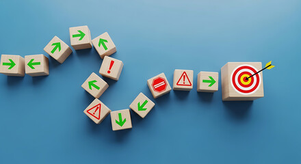 Obraz premium Wooden blocks with arrows, stop signs, and exclamation points lead to a target with an arrow, on a blue background.