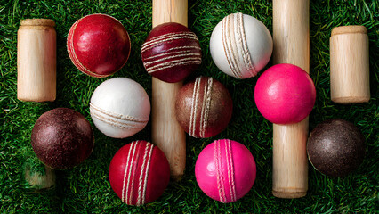 Overhead shot of cricket scorebook open beside boundary rope on grass, pen and scorer's accessories visible