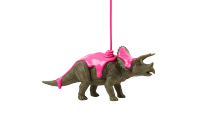 Triceratops toy covered in pink liquid against a black background in studio shot style view