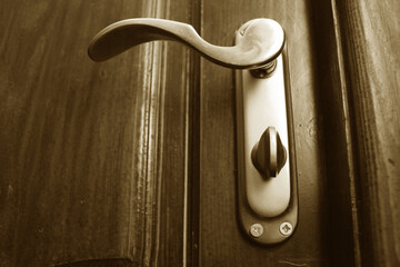 Close-up of an iron door handle on wooden door
