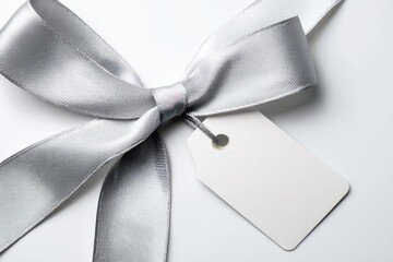 Elegant silver satin ribbon tied in a bow with a blank white gift tag for personalization and celebration