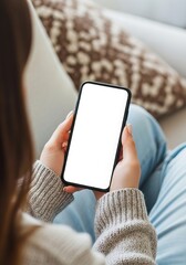 Woman holding a blank smartphone screen while relaxing on a couch in a cozy living room setting perfect for app and website mockups and showcasing mobile content