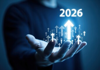 A hand holding glowing arrows pointing upward with the year two thousand twenty six